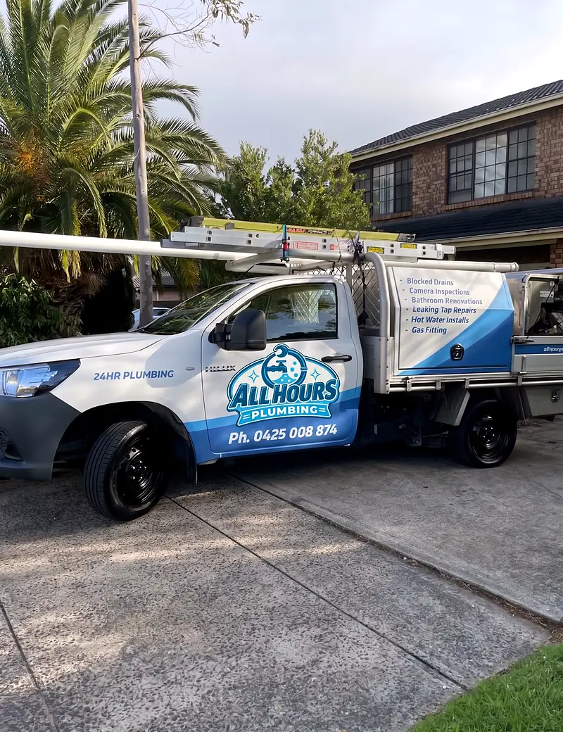 All Hours Plumbing ute with ladder rack and service signage parked in a residential driveway