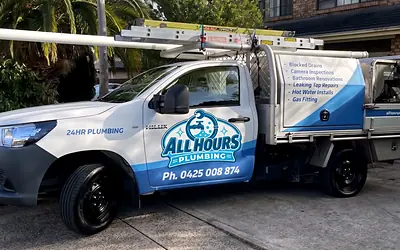 All Hours Plumbing ute with service signage parked in a driveway